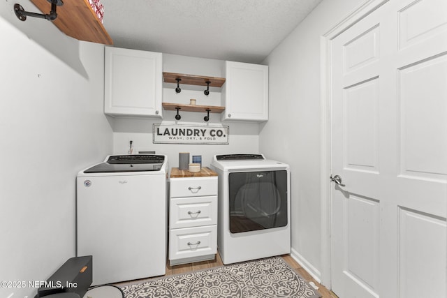 1565 Royal Fern Ln, Fleming Island, FL 32003 - laundry room featuring washing machine and dryer, cabinet space, light wood-type flooring, and a textured ceiling