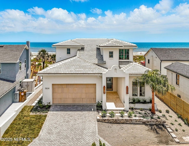 1509 Ocean Front, Neptune Beach, FL 32266 - view of front of home featuring stucco siding, decorative driveway, a water view, a garage, and a tile roof