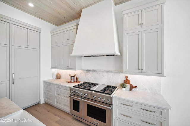 1509 Ocean Front, Neptune Beach, FL 32266 - kitchen featuring range with two ovens, custom range hood, decorative backsplash, wood ceiling, and light wood finished floors