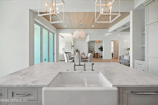 1509 Ocean Front, Neptune Beach, FL 32266 - kitchen with a chandelier, light stone countertops, wood ceiling, gray cabinets, and wood finished floors