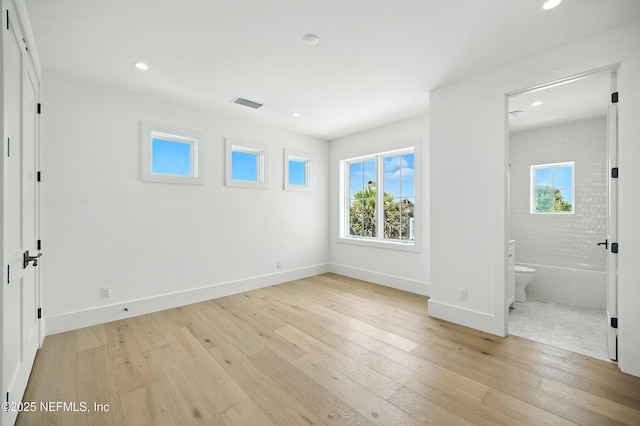 1509 Ocean Front, Neptune Beach, FL 32266 - unfurnished bedroom featuring multiple windows, light wood finished floors, recessed lighting, and ensuite bath