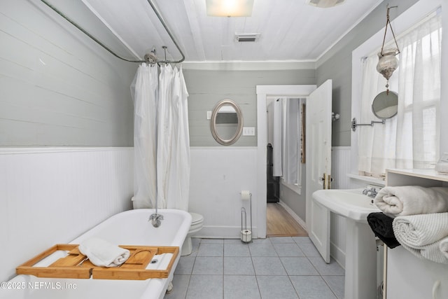 10 Venancio St, Saint Augustine, FL 32084 - bathroom featuring a soaking tub, tile patterned floors, a wainscoted wall, a shower with shower curtain, and wooden walls