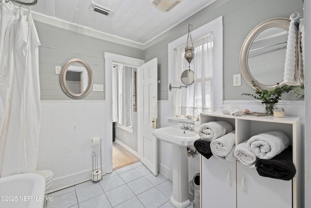 10 Venancio St, Saint Augustine, FL 32084 - full bath featuring tile patterned flooring, plenty of natural light, a wainscoted wall, and ornamental molding