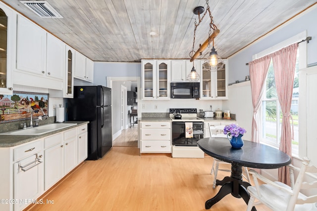 10 Venancio St, Saint Augustine, FL 32084 - kitchen with black appliances, glass insert cabinets, light wood-type flooring, and wooden ceiling