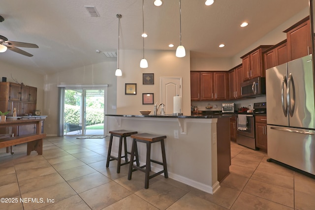 127 Colorado Springs Way, Saint Augustine, FL 32092 - kitchen with appliances with stainless steel finishes, dark countertops, a kitchen breakfast bar, light tile patterned floors, and recessed lighting