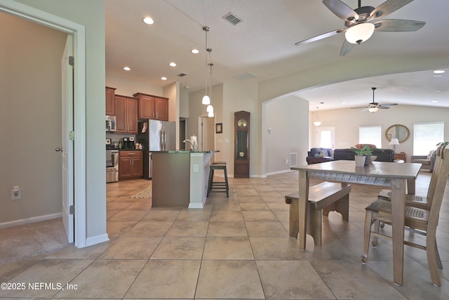 127 Colorado Springs Way, Saint Augustine, FL 32092 - kitchen featuring open floor plan, ceiling fan, appliances with stainless steel finishes, dark countertops, and a kitchen bar
