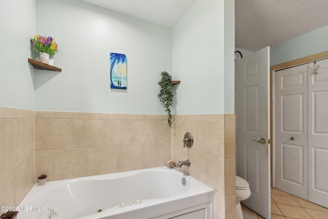 86385 Peeples Rd, Yulee, FL 32097 - full bath with a tub with jets, a closet, tile patterned floors, and a textured ceiling