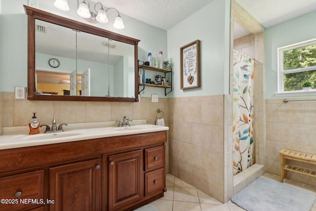 86385 Peeples Rd, Yulee, FL 32097 - bathroom with tile walls, double vanity, a tile shower, tile patterned floors, and a textured ceiling
