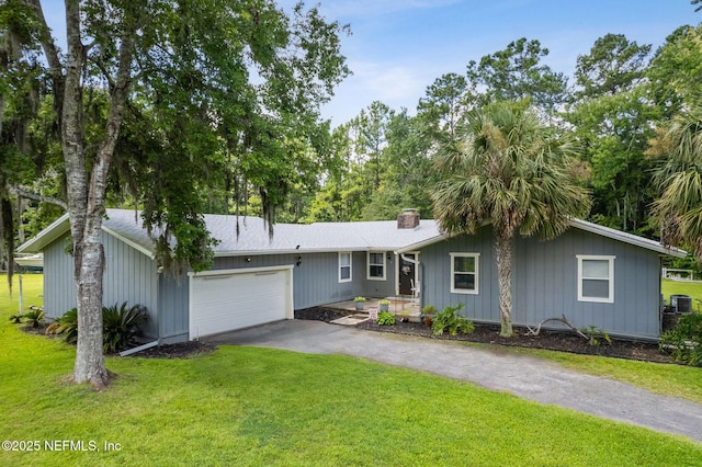 86385 Peeples Rd, Yulee, FL 32097 - view of front of property featuring a garage, asphalt driveway, a front lawn, and a chimney