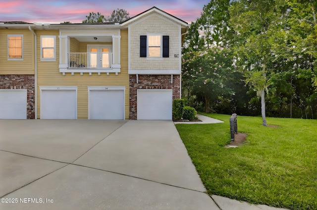 218 Larkin Pl Unit 105, Saint Johns, FL 32259 - view of front of house with driveway, a garage, a yard, a balcony, and brick siding