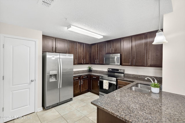 218 Larkin Pl Unit 105, Saint Johns, FL 32259 - kitchen with appliances with stainless steel finishes, dark brown cabinets, light tile patterned flooring, decorative light fixtures, and a textured ceiling