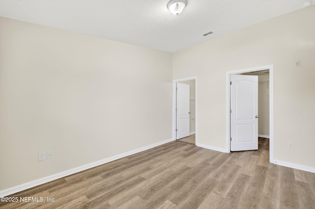218 Larkin Pl Unit 105, Saint Johns, FL 32259 - unfurnished bedroom with a walk in closet, wood finished floors, a textured ceiling, and a closet