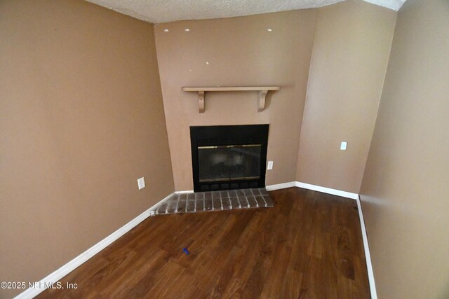 44186 Lee Dr, Callahan, FL 32011 - unfurnished living room with wood finished floors, a fireplace, and a textured ceiling