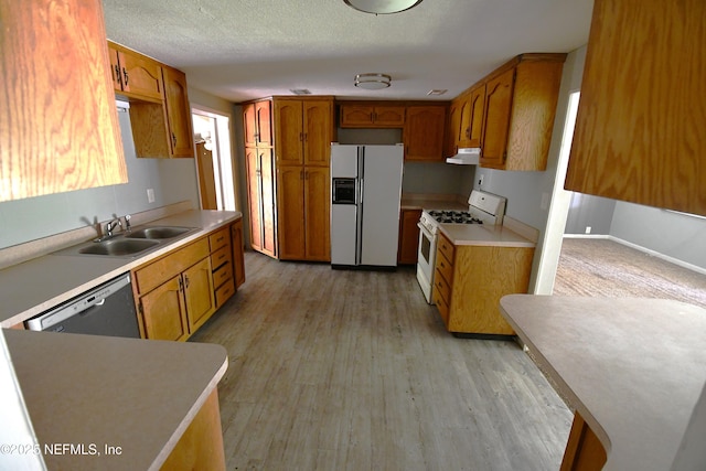 44186 Lee Dr, Callahan, FL 32011 - kitchen featuring white appliances, under cabinet range hood, and brown cabinets