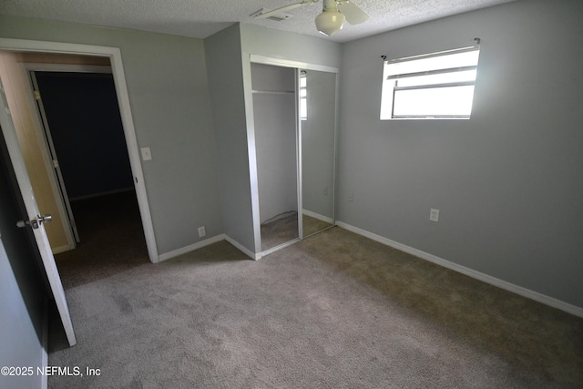 44186 Lee Dr, Callahan, FL 32011 - unfurnished bedroom featuring a textured ceiling, carpet flooring, a closet, and a ceiling fan