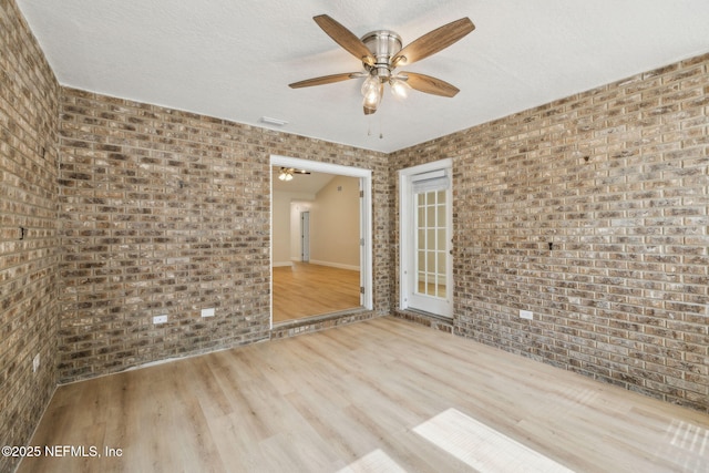 4804 Winton Cir, Saint Augustine, FL 32086 - spare room featuring brick wall, a ceiling fan, and wood finished floors