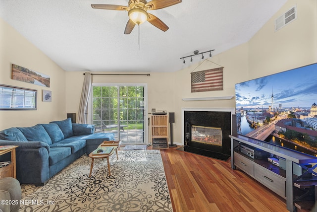 1133 Blue Sky Way, Jacksonville, FL 32225 - living room with a glass covered fireplace, wood finished floors, a ceiling fan, a textured ceiling, and track lighting