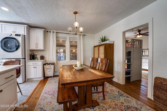 4818 Astral St, Jacksonville, FL 32205 - dining room featuring estacked washer and dryer, light wood-type flooring, ceiling fan, and a textured ceiling