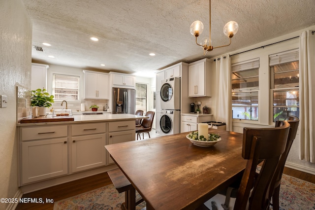 4818 Astral St, Jacksonville, FL 32205 - dining room featuring stacked washer / drying machine, dark wood finished floors, a textured ceiling, recessed lighting, and a chandelier