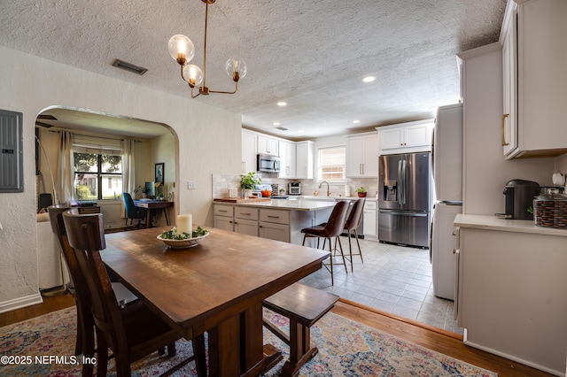 4818 Astral St, Jacksonville, FL 32205 - dining space with arched walkways, recessed lighting, a textured ceiling, light wood-style floors, and a chandelier