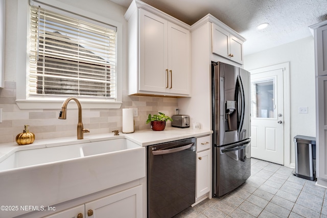 4818 Astral St, Jacksonville, FL 32205 - kitchen with stainless steel fridge, dishwasher, backsplash, light countertops, and a textured ceiling