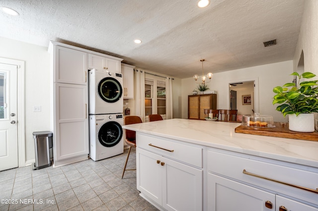 4818 Astral St, Jacksonville, FL 32205 - laundry area with stacked washer / dryer, a textured ceiling, recessed lighting, and light tile patterned floors