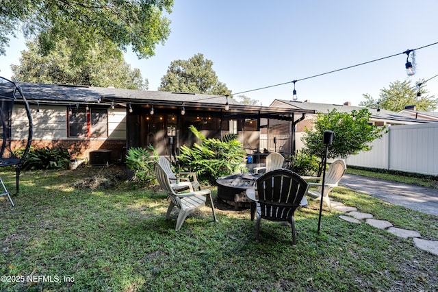 4818 Astral St, Jacksonville, FL 32205 - rear view of house featuring a fire pit, brick siding, and a trampoline