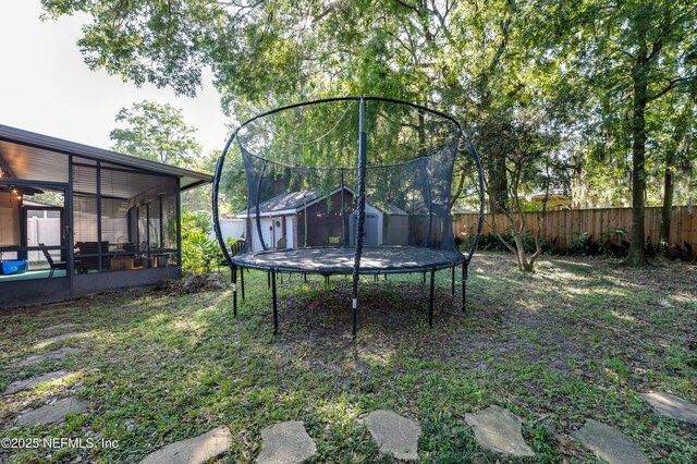 4818 Astral St, Jacksonville, FL 32205 - view of yard featuring a trampoline, a storage shed, and a sunroom
