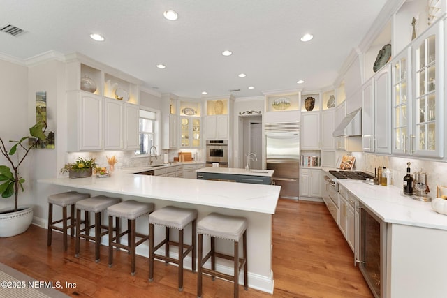 1614 Sheffield Park Ct, Jacksonville, FL 32225 - kitchen with stainless steel appliances, under cabinet range hood, a peninsula, ornamental molding, and recessed lighting