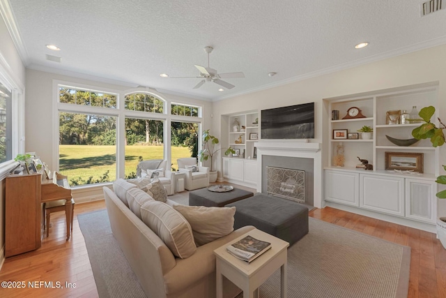 1614 Sheffield Park Ct, Jacksonville, FL 32225 - living room featuring a textured ceiling, ornamental molding, healthy amount of natural light, ceiling fan, and light wood finished floors