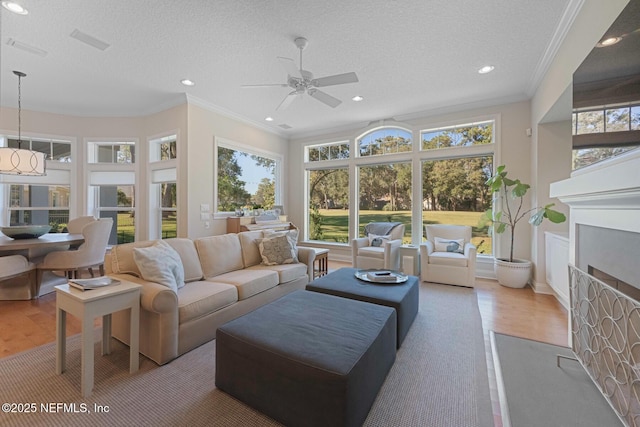 1614 Sheffield Park Ct, Jacksonville, FL 32225 - living area featuring wood finished floors, a fireplace with flush hearth, ornamental molding, a ceiling fan, and recessed lighting