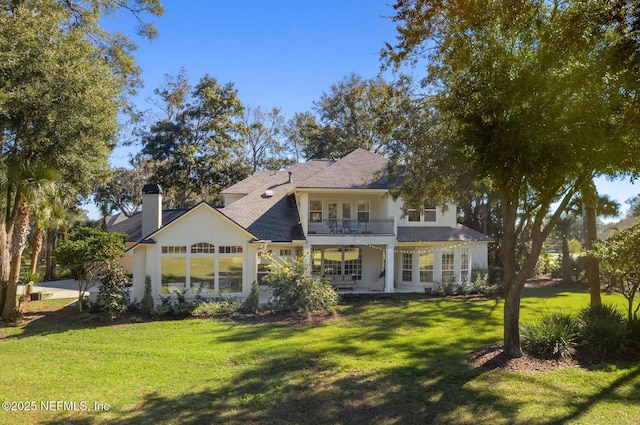 1614 Sheffield Park Ct, Jacksonville, FL 32225 - back of house featuring a balcony, a lawn, a chimney, and stucco siding