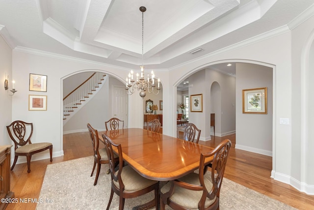 1614 Sheffield Park Ct, Jacksonville, FL 32225 - dining area featuring stairs, arched walkways, crown molding, light wood finished floors, and a chandelier