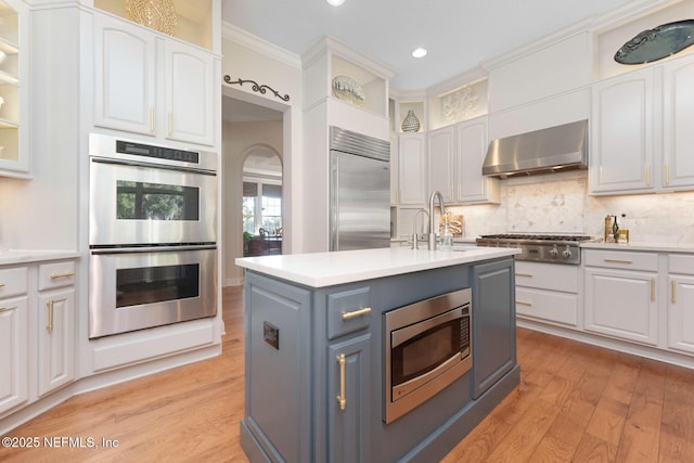 1614 Sheffield Park Ct, Jacksonville, FL 32225 - kitchen featuring built in appliances, wall chimney exhaust hood, white cabinets, light wood-style flooring, and recessed lighting