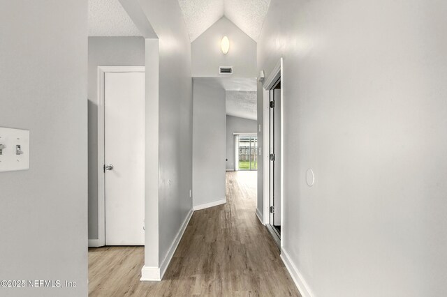 6719 Newgate Cir E, Jacksonville, FL 32244 - hallway featuring lofted ceiling, a textured ceiling, and wood finished floors
