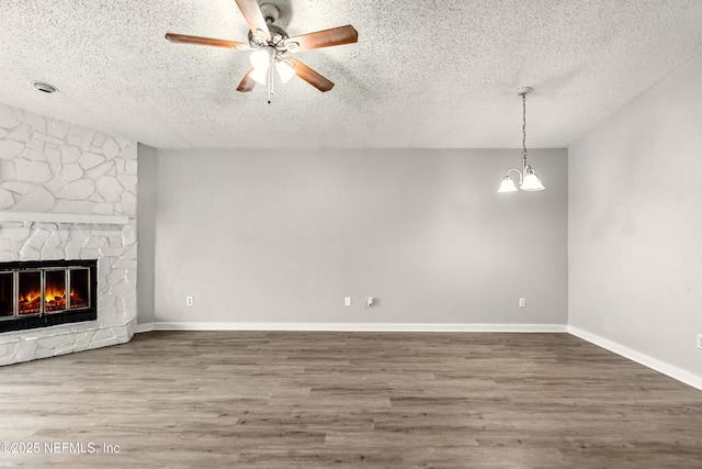 6719 Newgate Cir E, Jacksonville, FL 32244 - unfurnished living room featuring a textured ceiling, wood finished floors, a chandelier, a ceiling fan, and a fireplace