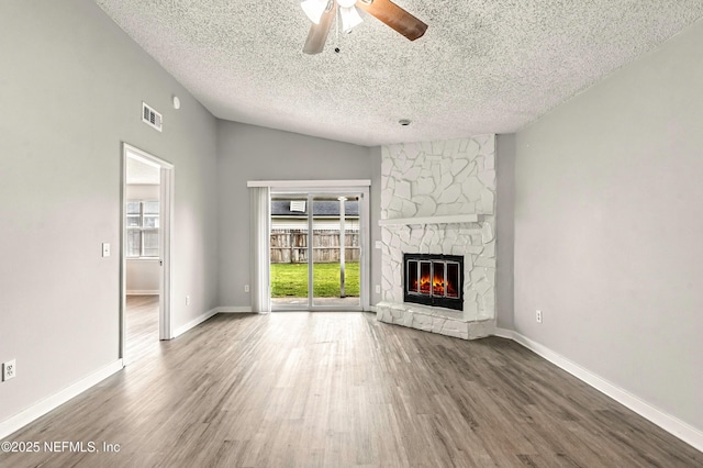 6719 Newgate Cir E, Jacksonville, FL 32244 - unfurnished living room with healthy amount of natural light, a textured ceiling, a fireplace, wood finished floors, and ceiling fan