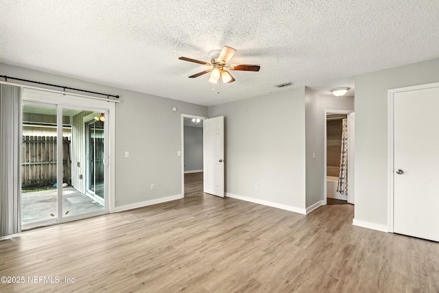 6719 Newgate Cir E, Jacksonville, FL 32244 - unfurnished bedroom featuring access to outside, light wood finished floors, a textured ceiling, and a ceiling fan