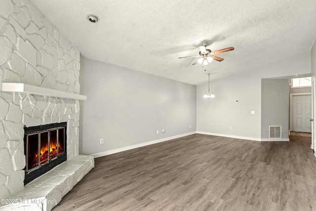 6719 Newgate Cir E, Jacksonville, FL 32244 - unfurnished living room featuring ceiling fan, a stone fireplace, a textured ceiling, wood finished floors, and lofted ceiling