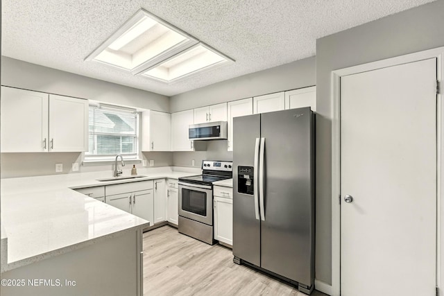 6719 Newgate Cir E, Jacksonville, FL 32244 - kitchen with appliances with stainless steel finishes, light wood-type flooring, white cabinetry, a textured ceiling, and light stone countertops