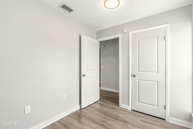 6719 Newgate Cir E, Jacksonville, FL 32244 - unfurnished bedroom with a textured ceiling and light wood-style floors