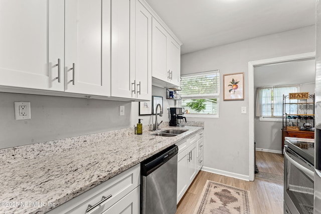 4737 College St, Jacksonville, FL 32205 - kitchen with stainless steel appliances, white cabinets, light wood-style flooring, and light stone countertops