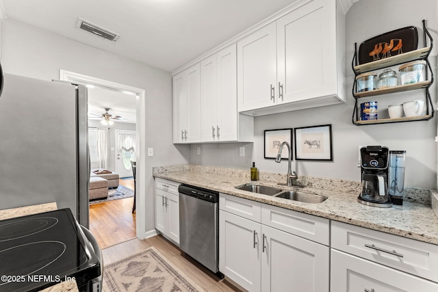 4737 College St, Jacksonville, FL 32205 - kitchen featuring appliances with stainless steel finishes, light wood finished floors, white cabinets, and a ceiling fan