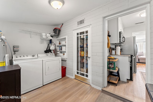 4737 College St, Jacksonville, FL 32205 - laundry room featuring washer and clothes dryer, light wood finished floors, and water heater
