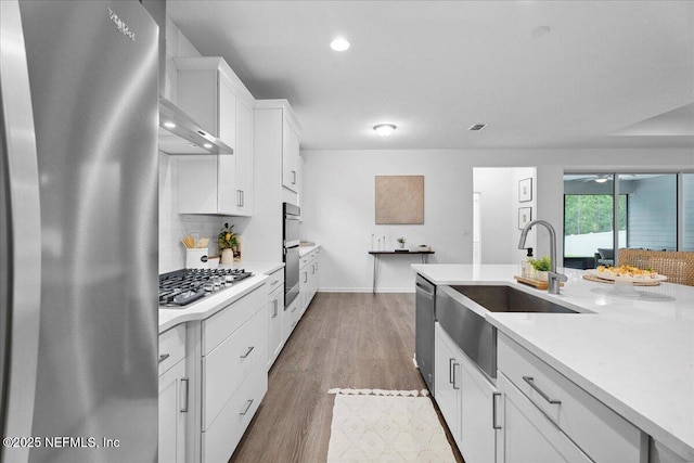 227 Wind Chime Ln, Saint Augustine, FL 32095 - kitchen featuring stainless steel appliances, light countertops, tasteful backsplash, white cabinets, and wall chimney range hood