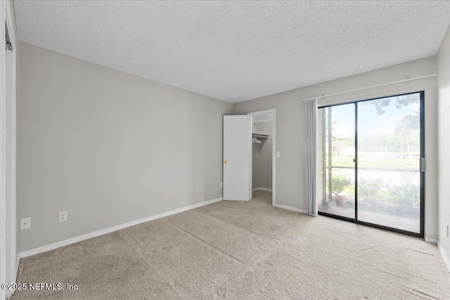 10200 Belle Rive Blvd Unit 79, Jacksonville, FL 32256 - unfurnished bedroom with access to outside, carpet, a textured ceiling, and a walk in closet