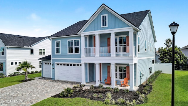 62 Seaside Vista Ct, Saint Augustine, FL 32084 - view of front of home featuring covered porch, board and batten siding, a balcony, a garage, and decorative driveway