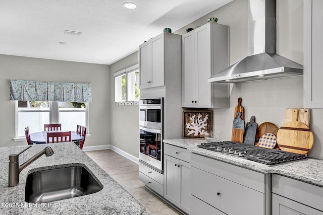 62 Seaside Vista Ct, Saint Augustine, FL 32084 - kitchen with wall chimney range hood, appliances with stainless steel finishes, light stone counters, light tile patterned floors, and recessed lighting