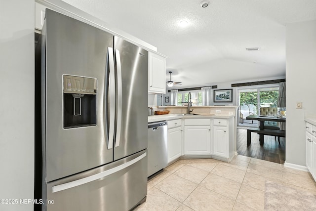 145 E Blackjack Branch Way, Saint Johns, FL 32259 - kitchen with appliances with stainless steel finishes, a peninsula, white cabinets, light countertops, and a textured ceiling