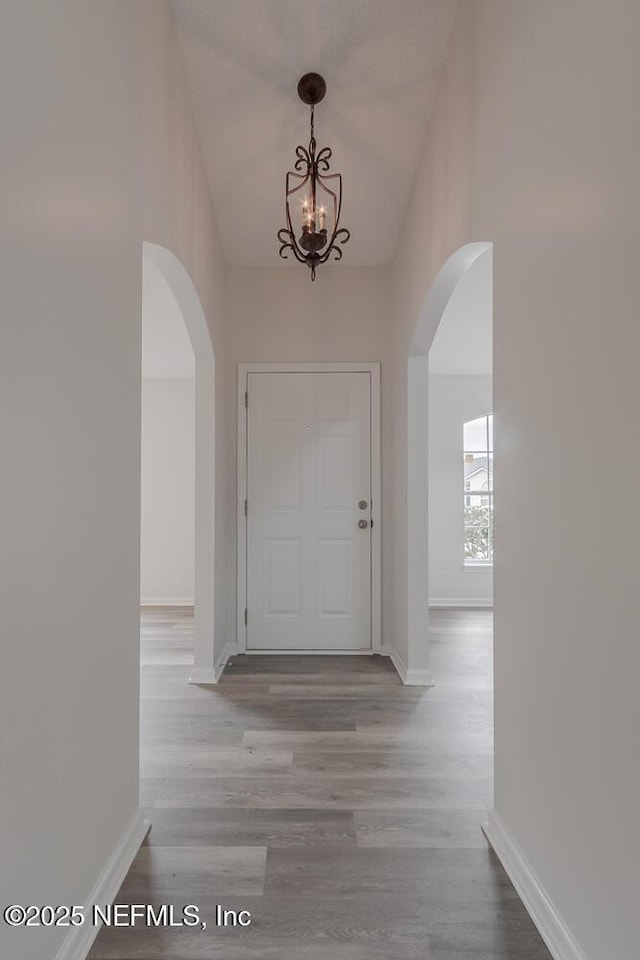 1203 Summer Springs Dr, Middleburg, FL 32068 - foyer featuring arched walkways, a chandelier, and wood finished floors